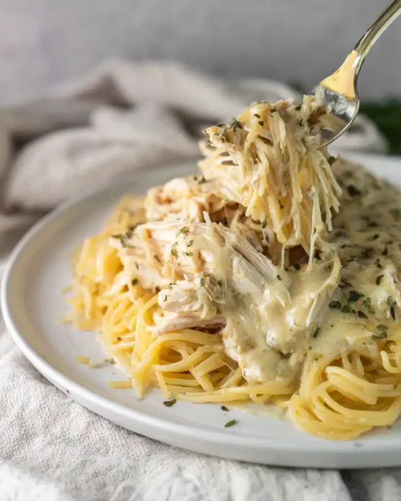 Crockpot Angel Chicken (Creamy Slow Cooker Favorite) 1 Creamy Crockpot Angel Chicken with pasta and sauce on a plate
