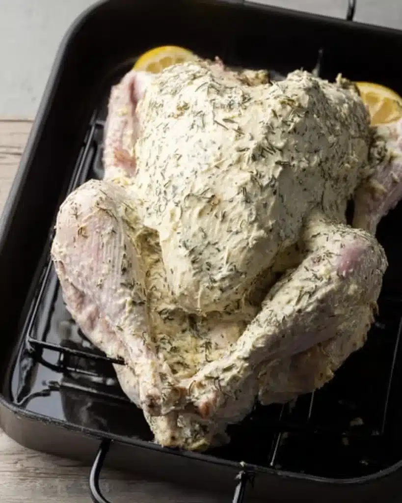 Easy Roast Turkey (Christmas Recipe) 2 Raw turkey coated with herb butter on roasting rack ready for oven