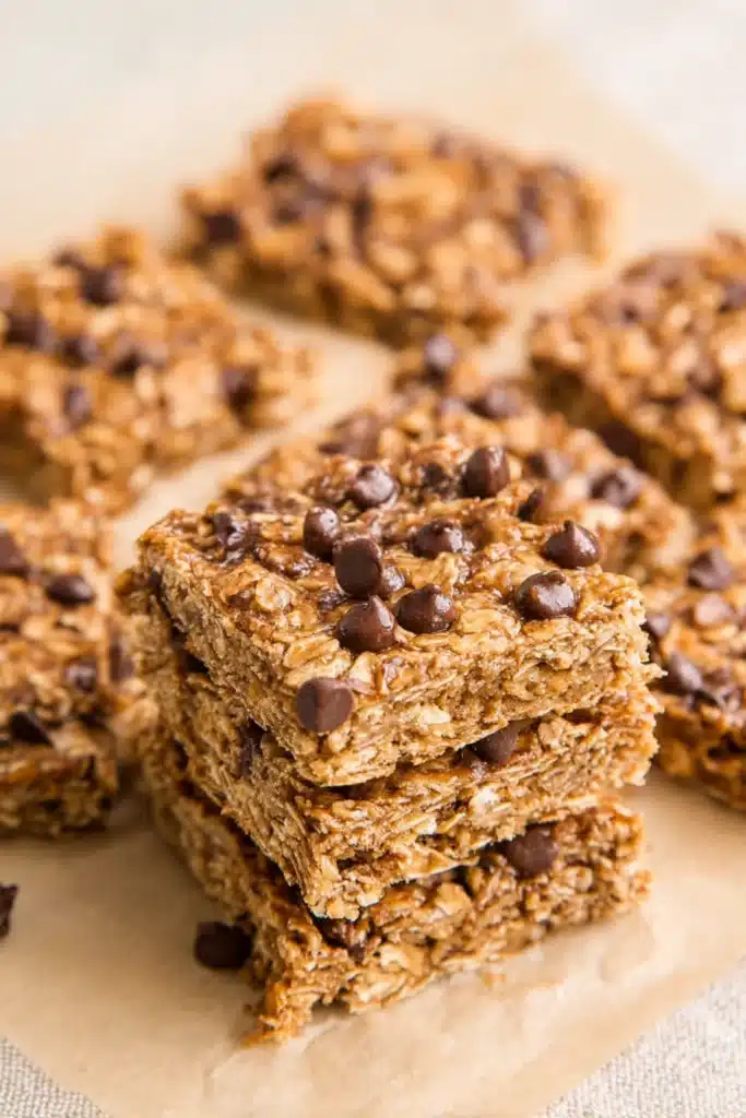 Healthy Banana Oatmeal Bars 1 Healthy banana oatmeal bars with chocolate chips stacked on a beige surface