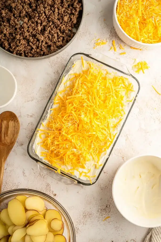 Hobo Casserole 4 Layered Hobo Casserole topped with shredded cheddar cheese before baking