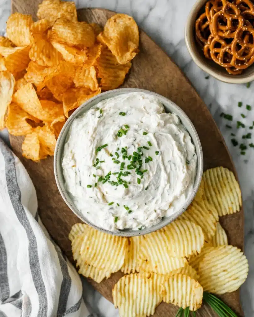 Sour Cream and Onion Dip 3 Sour cream and onion dip with chips and pretzels on a wooden board
