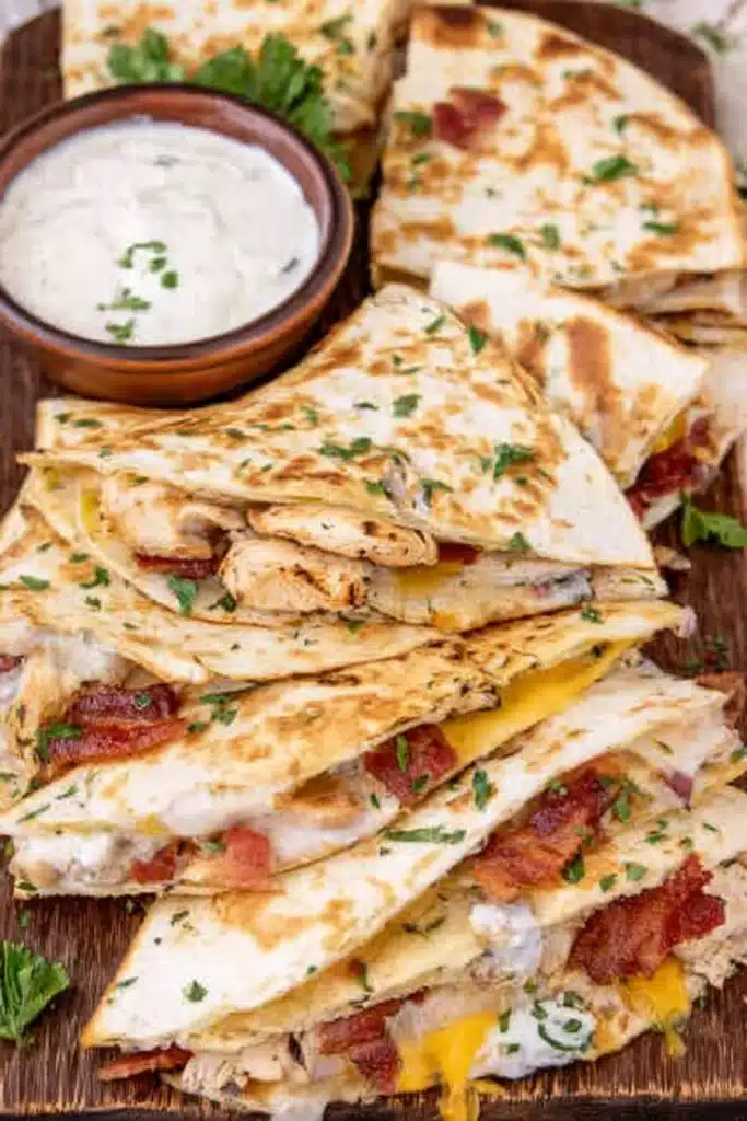 Chicken bacon ranch quesadilla slices with ranch dip on wooden board