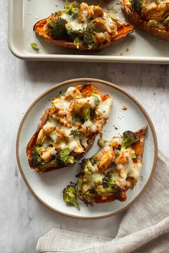 Chicken and Broccoli Stuffed Sweet Potatoes (Easy, Healthy Chicken Dinner Recipe) 1 Chicken and broccoli stuffed sweet potatoes with melted cheese on a ceramic plate