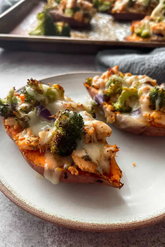 Chicken and Broccoli Stuffed Sweet Potatoes (Easy, Healthy Chicken Dinner Recipe) 4 Close-up of chicken and broccoli stuffed sweet potatoes with melted cheese on a plate