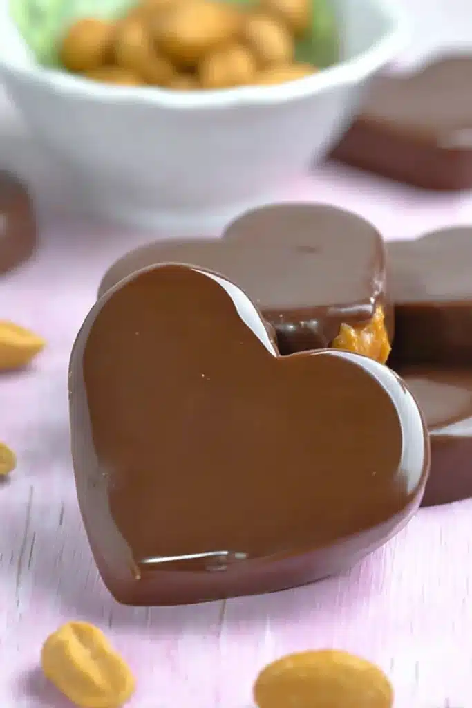 Chocolate Peanut Butter Valentine’s Hearts 1 Heart-shaped chocolate peanut butter candies on pink surface
