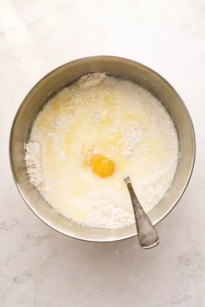 Pancake Casserole (Blueberry Baked Pancake) 2 Mixing pancake casserole batter with milk, butter, flour, and egg in a metal bowl