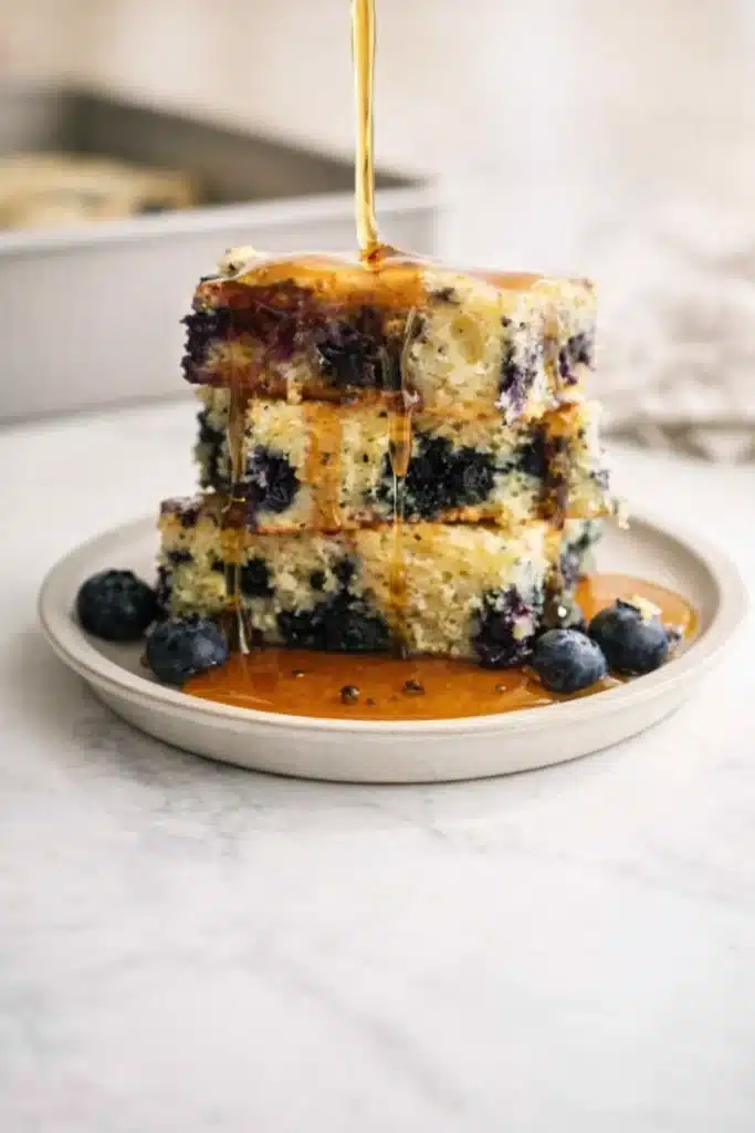 Pancake Casserole (Blueberry Baked Pancake) 1 Blueberry pancake casserole stack with syrup drizzle and fresh blueberries