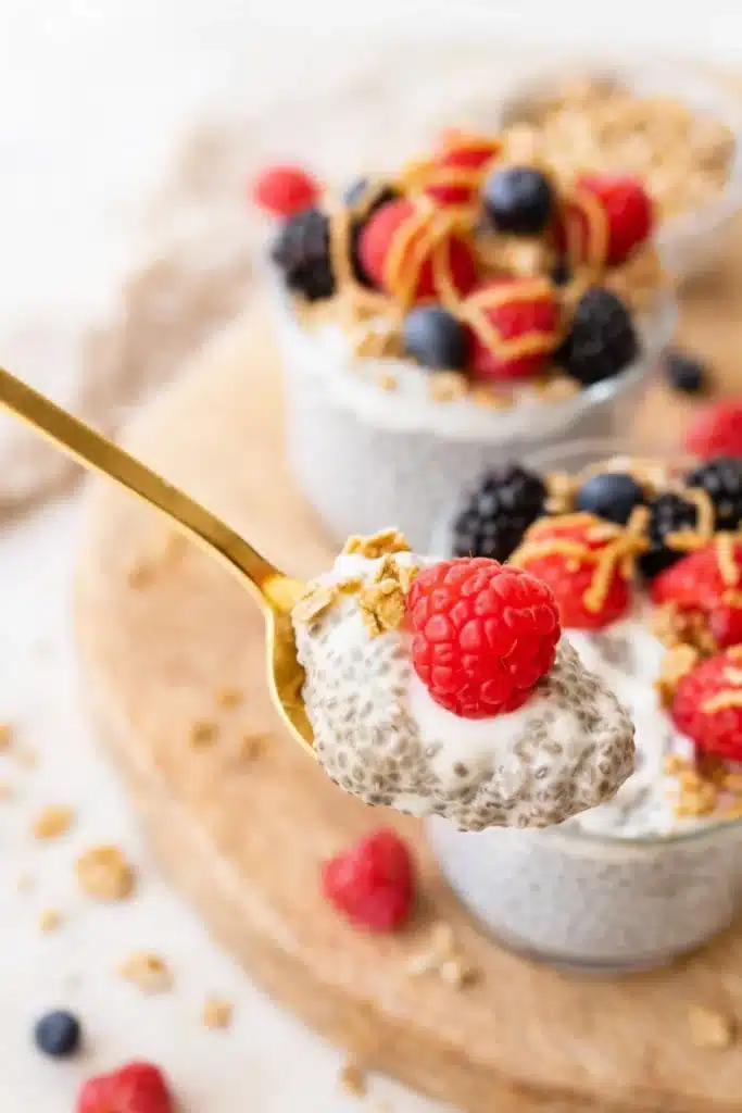 Protein Chia Pudding 3 Spoonful of creamy protein chia pudding with raspberry and granola