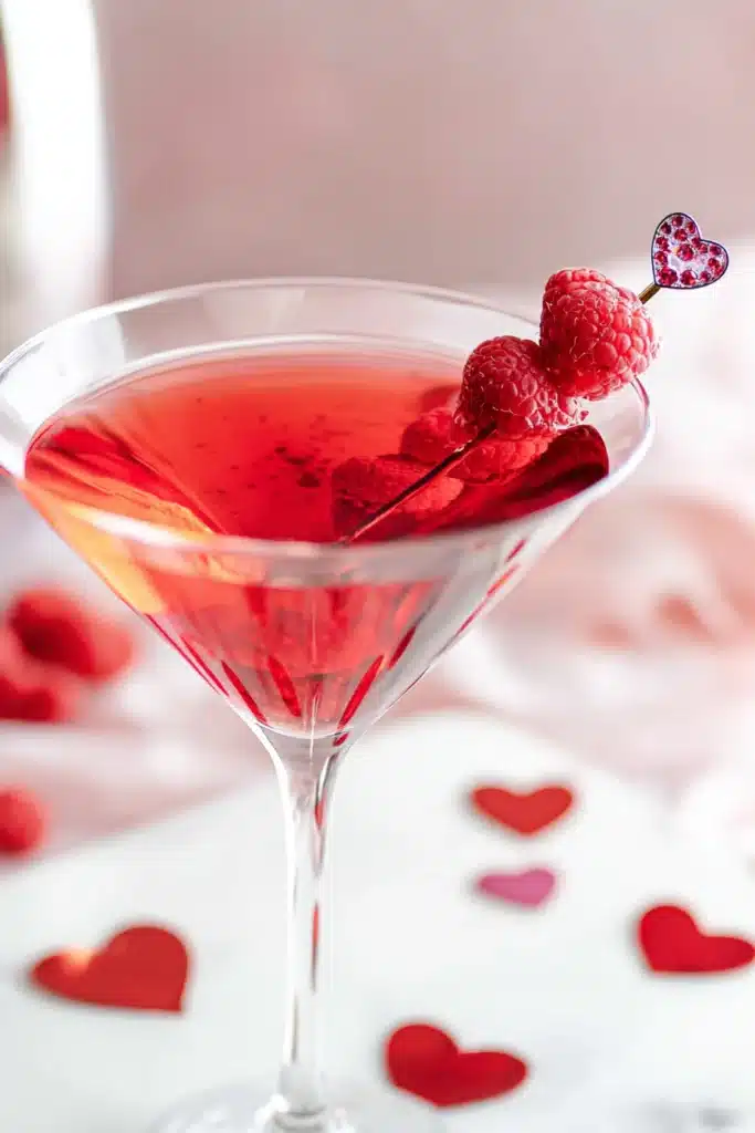 Red love potion cocktail in martini glass with raspberries for Valentine’s Day