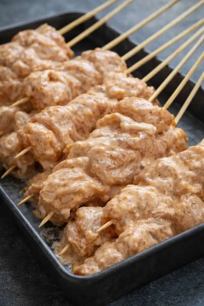Raw Bang Bang Chicken Skewers coated in creamy chili sauce