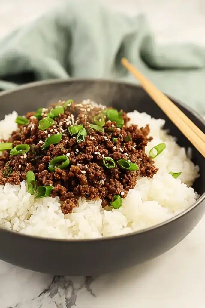 Delicious Korean Ground Beef Bowl 1 Korean ground beef bowl with rice, sesame seeds, and green onions