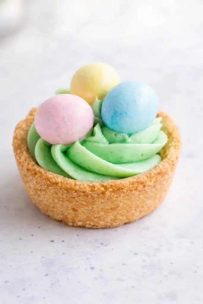 Easter Basket Sugar Cookie Cups 3 Close-up Easter Basket Sugar Cookie Cups with green frosting and pastel candy eggs