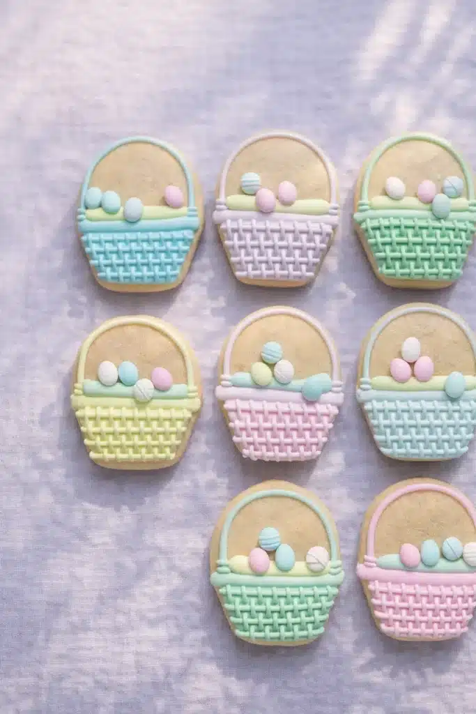 Pastel Easter basket sugar cookies decorated with royal icing and candy eggs
