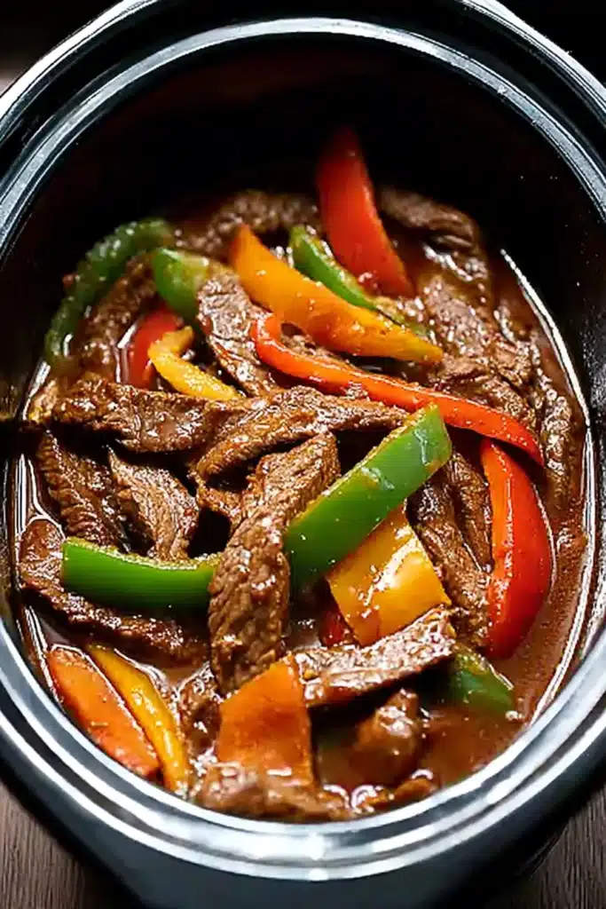 Easy Crockpot Pepper Steak 2 Easy Crockpot Pepper Steak with beef and colorful bell peppers simmering in sauce
