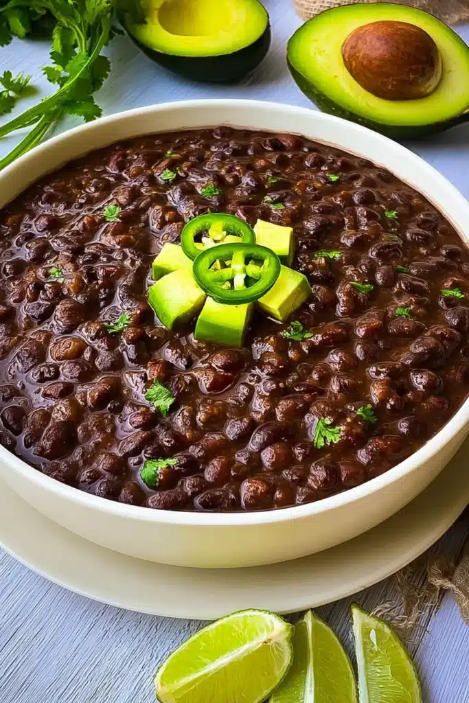 Instant Pot Black Bean Soup (Easy, Hearty & Flavorful) 1 Instant Pot black bean soup topped with avocado and jalapeño slices in a white bowl
