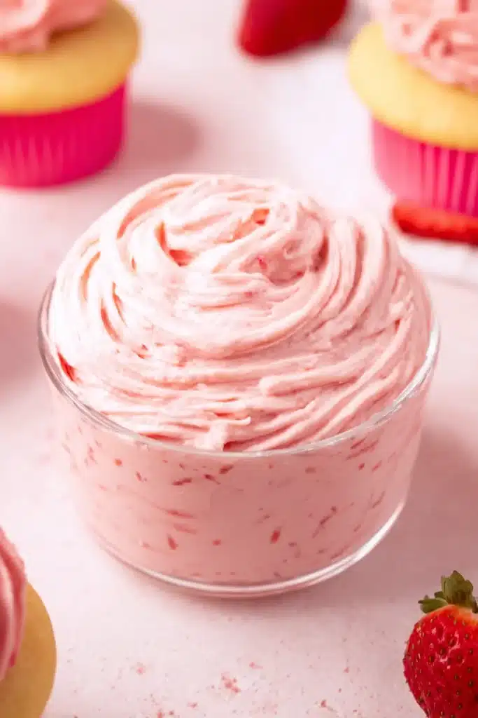 Strawberry Buttercream Frosting Recipe 2 Fluffy strawberry buttercream frosting in a glass bowl with cupcakes
