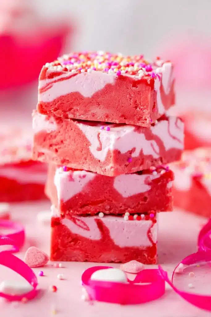 Stack of pink and red strawberry fudge squares with sprinkles