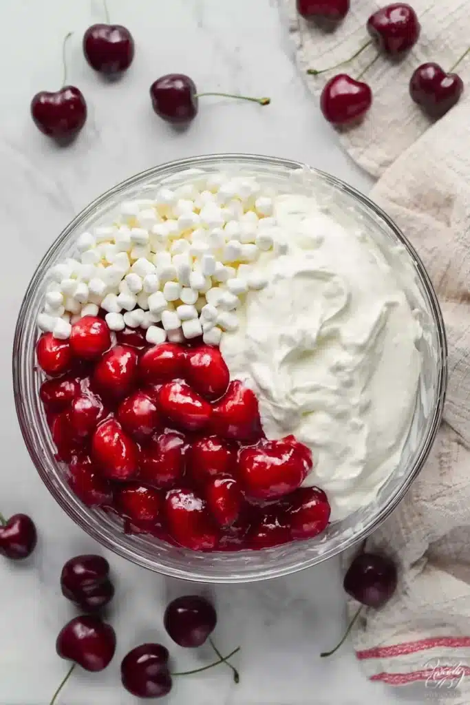 Cherry Cheesecake Fluff That’s Creamy, Easy, and Crowd Pleasing 2 Cherry Cheesecake Fluff ingredients in glass bowl with marshmallows and cherry filling