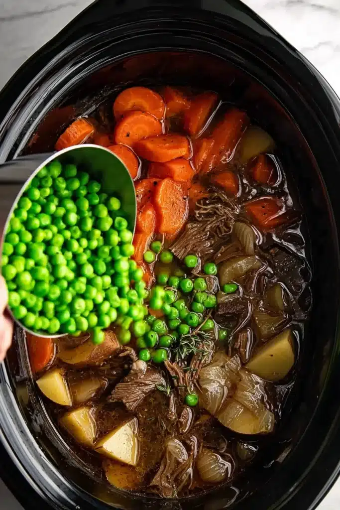 Crockpot Beef Stew Recipe: Easy, Hearty, and Comforting 2 Adding peas to Crockpot beef stew in slow cooker