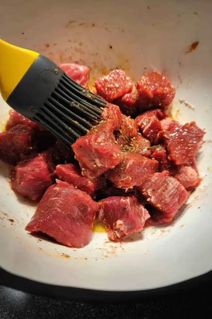 Garlic Butter Air Fryer Steak Bites 2 Garlic Butter Air Fryer Steak Bites raw steak cubes being seasoned in bowl