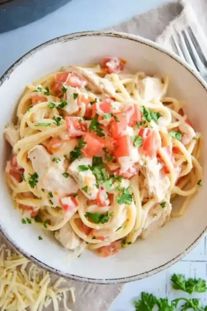 Instant Pot Chicken Spaghetti 1 Creamy instant pot chicken spaghetti with tomatoes and parsley in white bowl