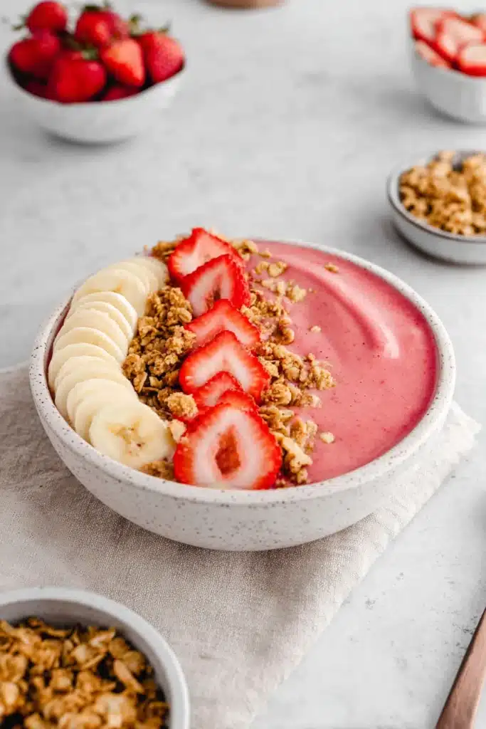 Strawberry banana smoothie bowl with granola, fresh fruit, and creamy texture