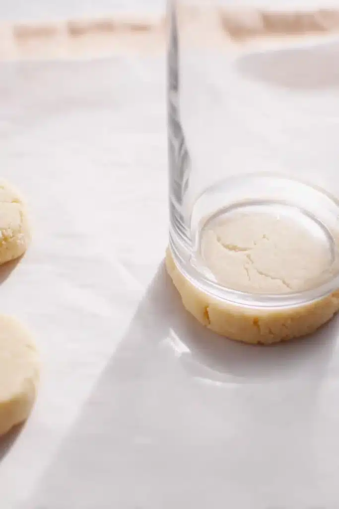 The Best Easter Sugar Cookies for a Soft and Festive Treat 2 The best easter Sugar Cookies dough flattened with glass on parchment paper