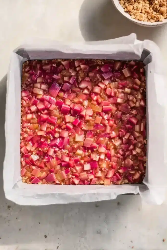 Rhubarb Crumble Bars 2 Rhubarb crumble bars filling spread in pan before baking
