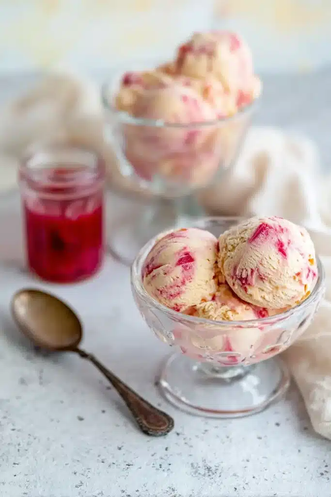 Rhubarb Ice Cream: A Creamy, Tangy Homemade Treat 1 Creamy rhubarb ice cream with pink swirls served in bowls with rhubarb sauce