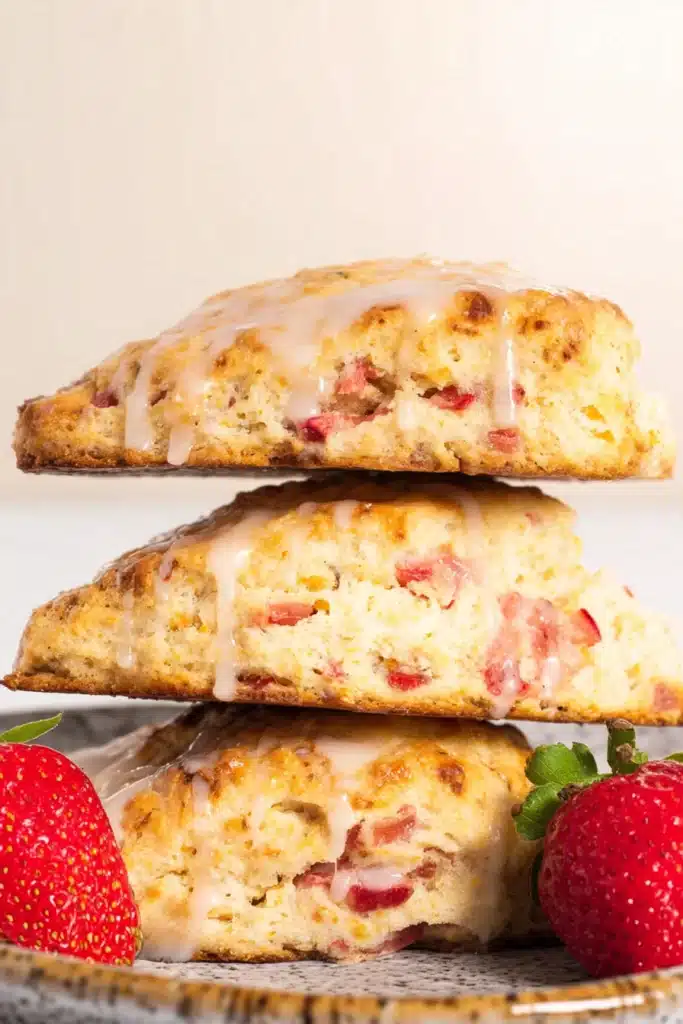Strawberry Rhubarb Scones 1 Strawberry rhubarb scones stacked with glaze and fresh strawberries