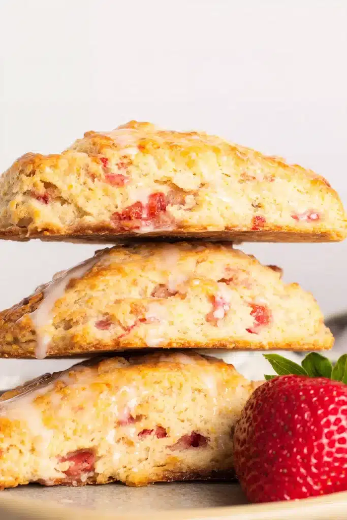 Strawberry Rhubarb Scones 4 Strawberry Rhubarb Scones stacked with golden crust and fresh strawberries