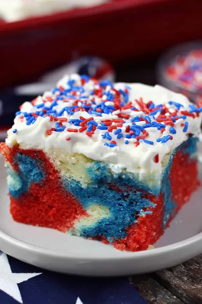 Patriotic Poke Cake That’s Bright, Easy, and Crowd-Pleasing 3 Close up of Patriotic Poke Cake showing red white blue texture and sprinkles