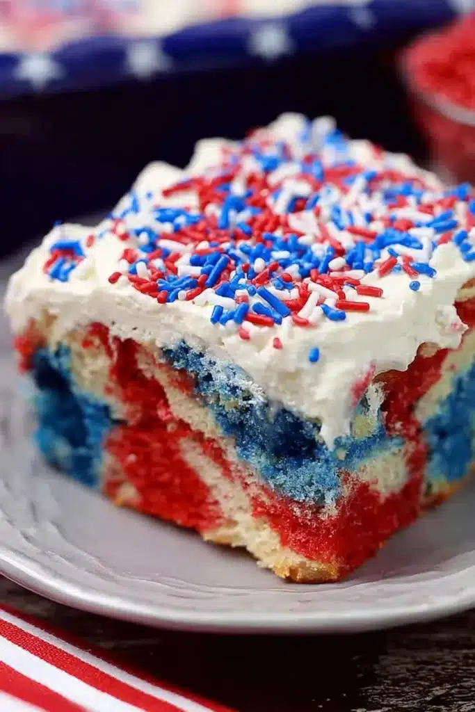 Patriotic Poke Cake That’s Bright, Easy, and Crowd-Pleasing 1 Patriotic Poke Cake slice with red white and blue layers and whipped topping