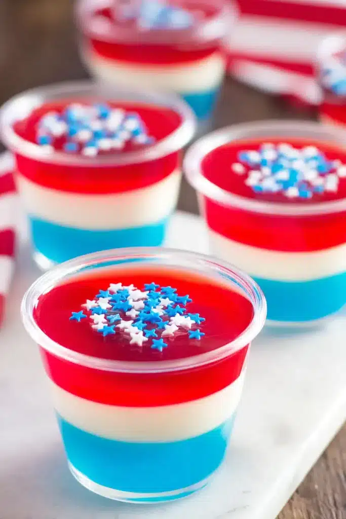 Red White & Blue Jello Shots 1 Red White & Blue Jello Shots layered dessert cups with sprinkles on platter