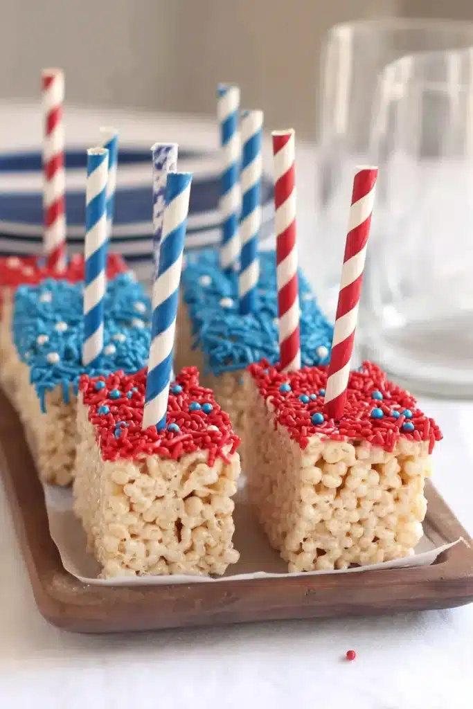 American Flag Rice Krispie Treats with red and blue coating and sprinkles on serving tray
