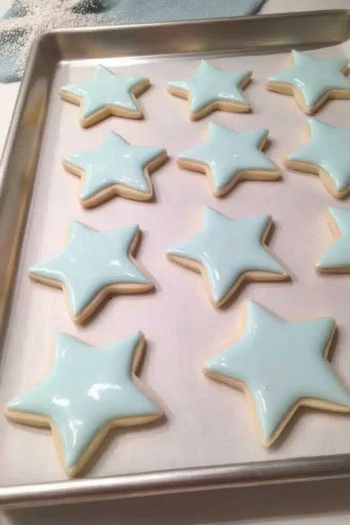Star Cookies 3 Star Cookies with blue royal icing and patriotic sprinkle borders on a rustic wood surface