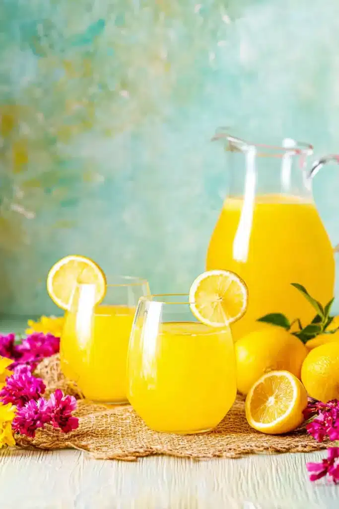 Fresh Mango Lemonade 1 Fresh Mango Lemonade served in glasses with lemon slices and summer flowers