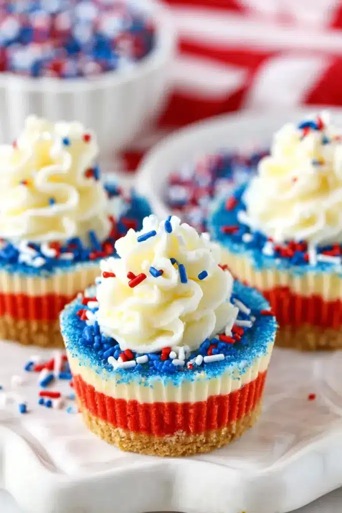 Red White and Blue Mini Cheesecakes 2 Red White and Blue Mini Cheesecakes with whipped cream and patriotic sprinkles