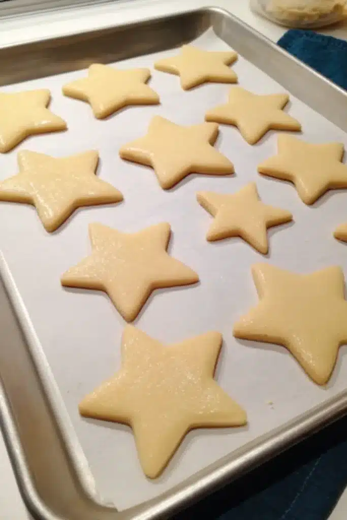 Star Cookies 2 Star Cookies with light blue royal icing on a parchment lined baking sheet
