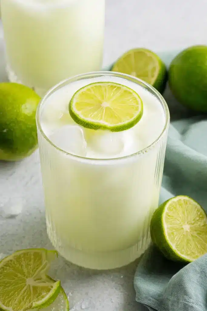 Brazilian Lemonade with lime slices and ice in a creamy citrus drink