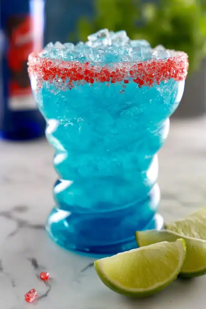 Firecracker Margarita Recipe 2 Firecracker Margarita with blue curaçao, crushed ice, and red candy rim