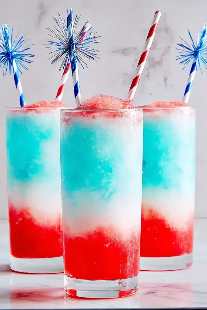 Frozen Bomb Pop Cocktail 1 Three Frozen Bomb Pop Cocktails with red white and blue frozen layers in tall glasses