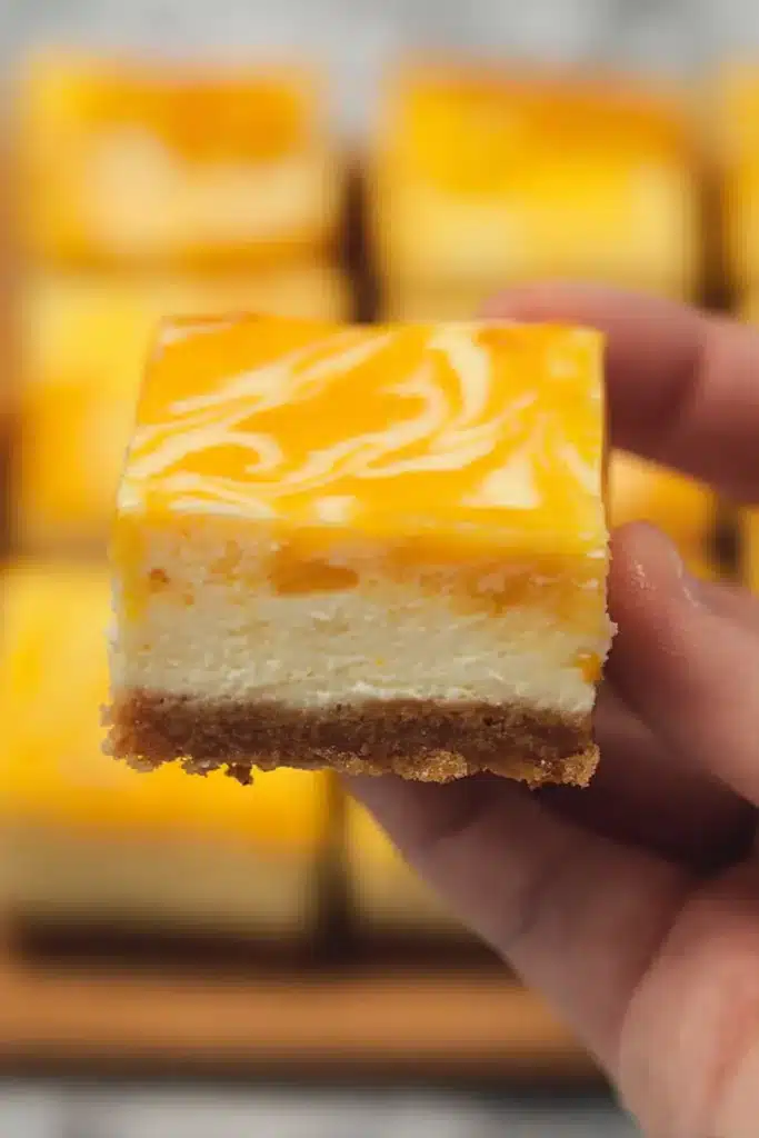 Mango Cheesecake Bars 2 Mango cheesecake bar with creamy filling, mango swirl topping, and graham cracker crust