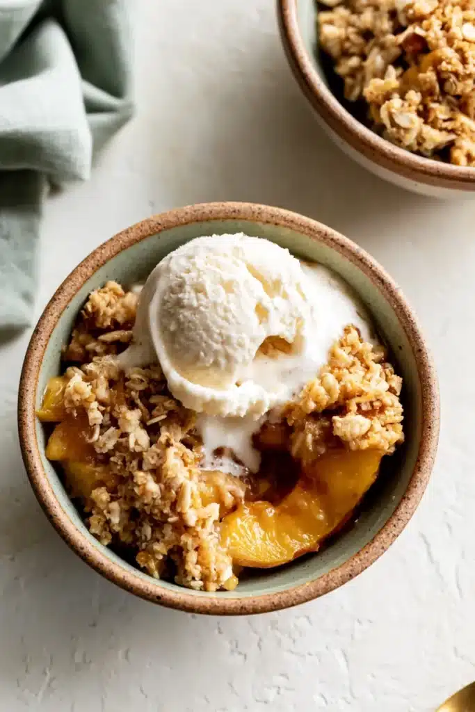Peach Crisp Recipe 6 Peach Crisp served with vanilla ice cream in a rustic bowl