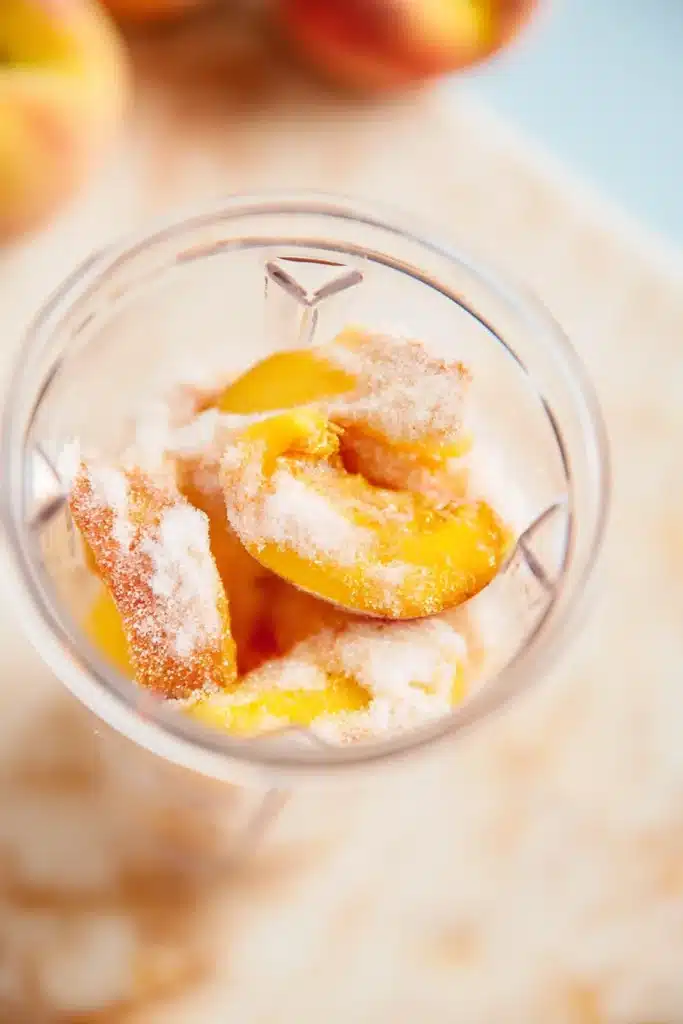 Peach Sorbet ingredients with peaches and sugar in a blender