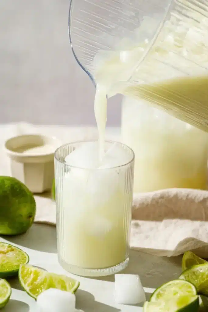 Brazilian Lemonade being poured over ice into a serving glass