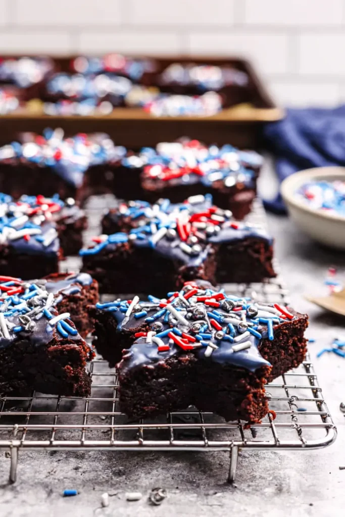 Star-Spangled Brownies with blue drizzle and patriotic sprinkles on a rack